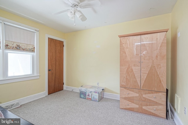 carpeted bedroom with a ceiling fan, visible vents, and baseboards