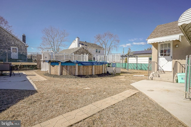 view of yard featuring entry steps, a patio area, fence, and a fenced in pool