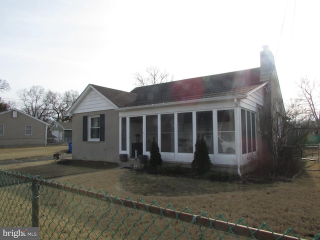 view of front of property with a sunroom and a front yard