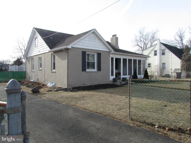 view of front of property with a sunroom and a front lawn