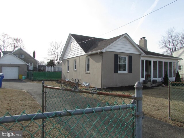 view of side of property with a garage, a sunroom, and a lawn