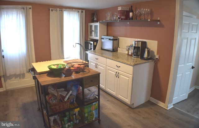 kitchen featuring plenty of natural light, white cabinetry, and dark wood finished floors