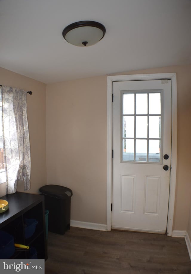 doorway to outside with baseboards and wood finished floors