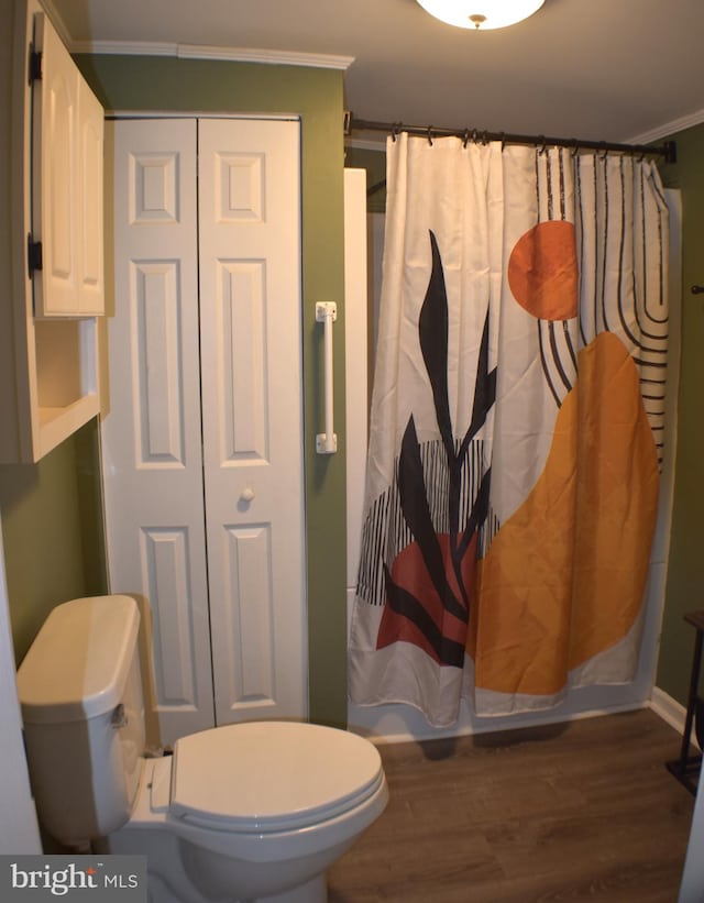 bathroom with ornamental molding, curtained shower, toilet, and wood finished floors