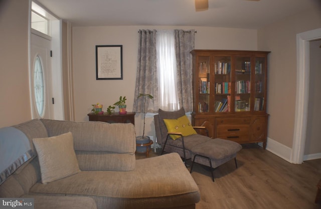 living room featuring a wealth of natural light, ceiling fan, baseboards, and wood finished floors