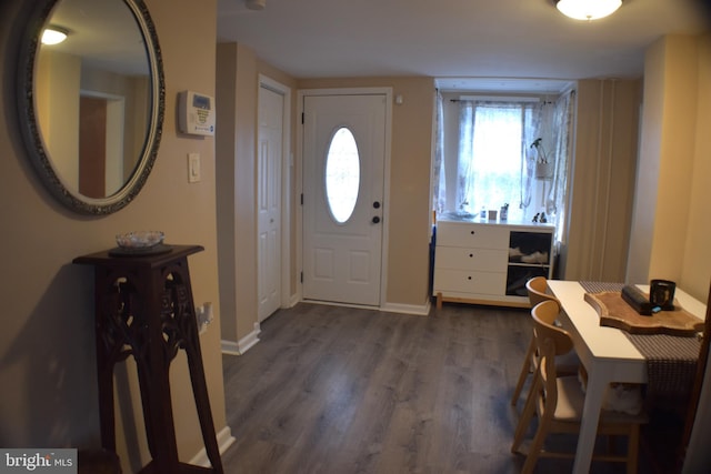 foyer featuring baseboards and dark wood finished floors