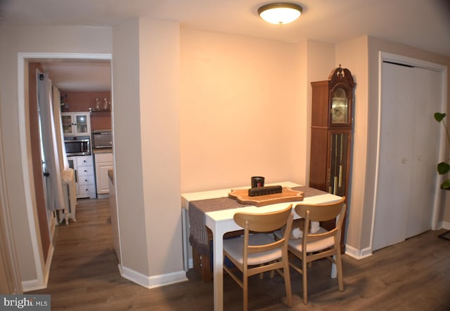 dining space with baseboards and wood finished floors