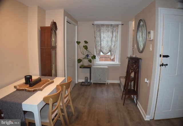 dining room featuring radiator, dark wood-style floors, and baseboards