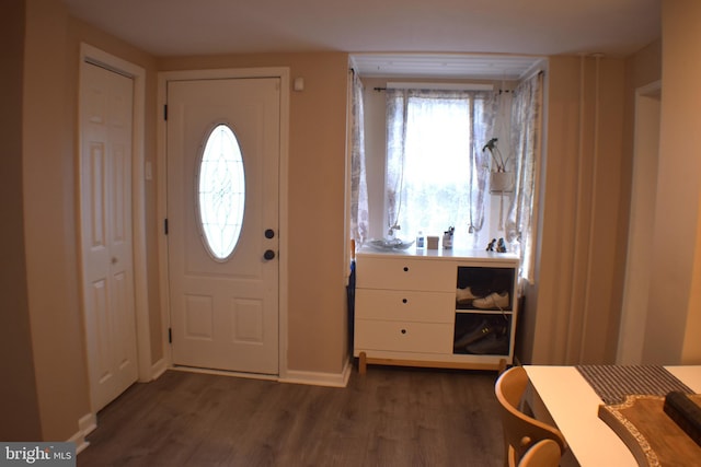 foyer with dark wood finished floors and baseboards