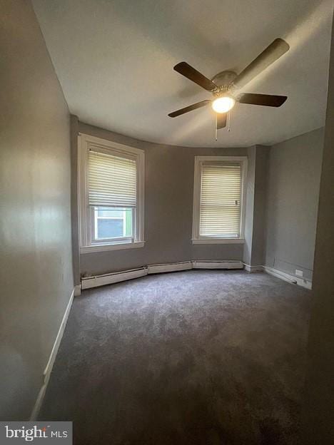 carpeted spare room with ceiling fan and a baseboard heating unit