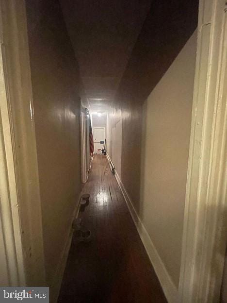 hallway with dark hardwood / wood-style flooring