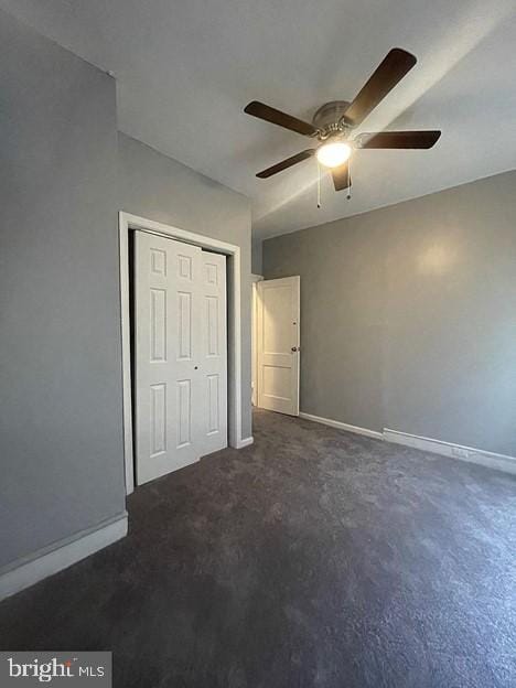 unfurnished bedroom with ceiling fan and a closet