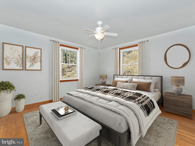 bedroom with multiple windows, ceiling fan, and light hardwood / wood-style floors