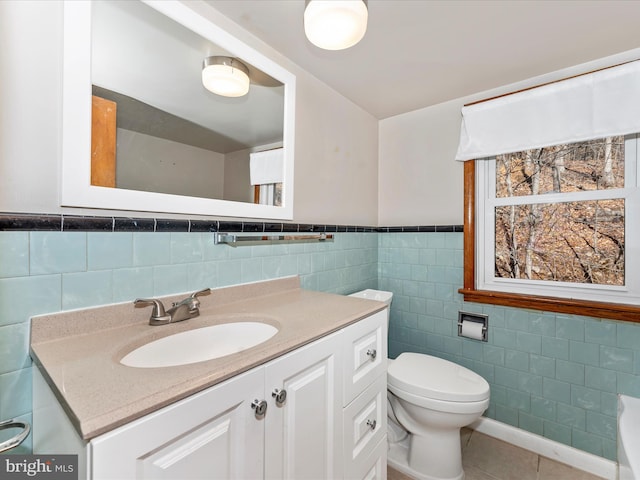 bathroom featuring tile walls, vanity, tile patterned flooring, and toilet