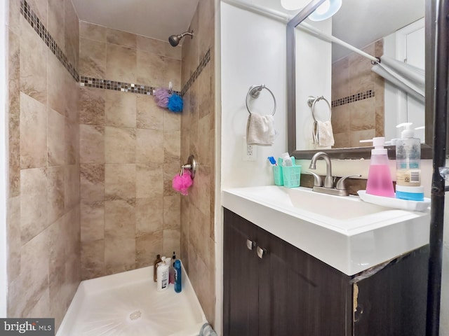 bathroom with vanity and a tile shower