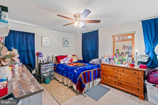 bedroom featuring light carpet and ceiling fan