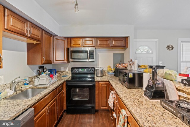 kitchen with dark hardwood / wood-style flooring, light stone countertops, sink, and black appliances