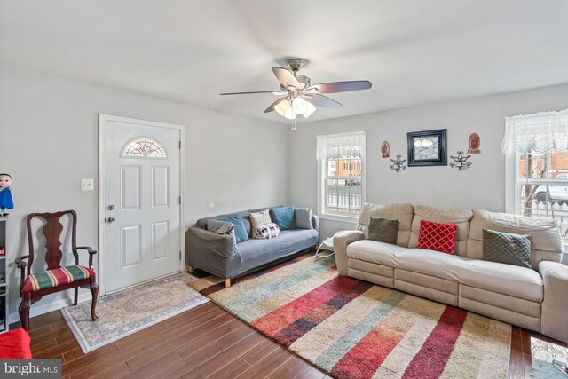 living room featuring dark wood-type flooring and ceiling fan