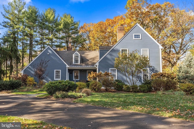 cape cod-style house with a front lawn