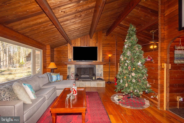 unfurnished living room featuring vaulted ceiling with beams, hardwood / wood-style flooring, wooden walls, and wooden ceiling