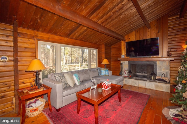 living room with wood ceiling, hardwood / wood-style floors, lofted ceiling with beams, a stone fireplace, and log walls