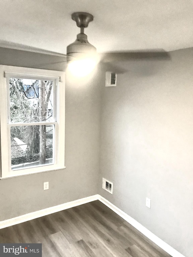 interior space with dark wood-type flooring, visible vents, and baseboards