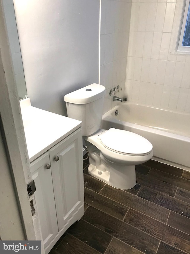 bathroom featuring  shower combination, wood finish floors, vanity, and toilet