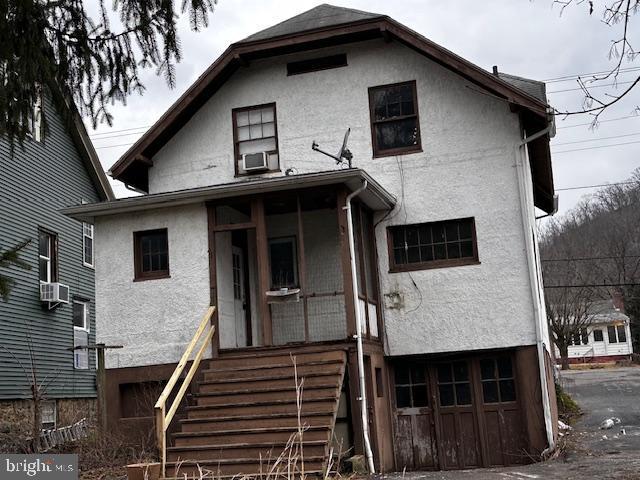 view of front of house with a garage and cooling unit