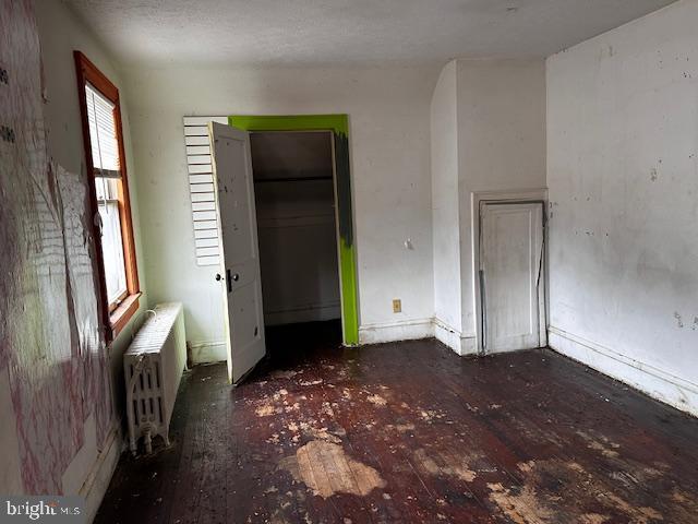 unfurnished bedroom featuring radiator heating unit