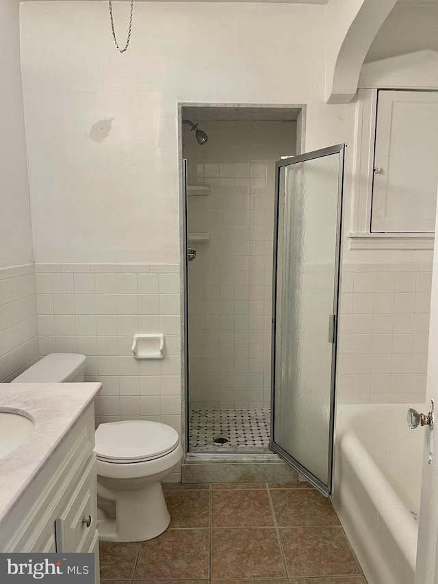 full bathroom featuring independent shower and bath, vanity, tile patterned flooring, and toilet