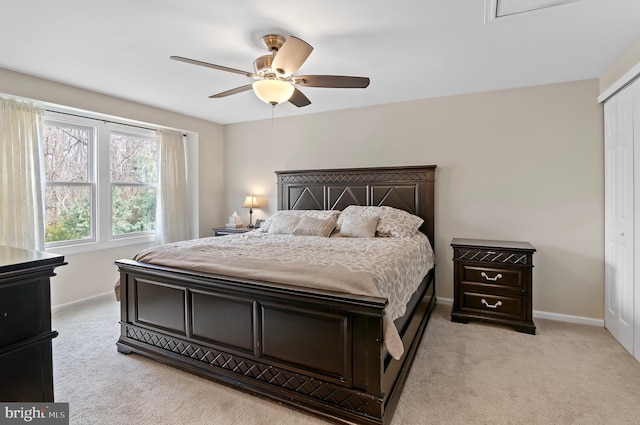 bedroom featuring ceiling fan, a closet, and light carpet