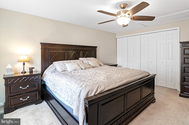 bedroom with light colored carpet, ceiling fan, and a closet