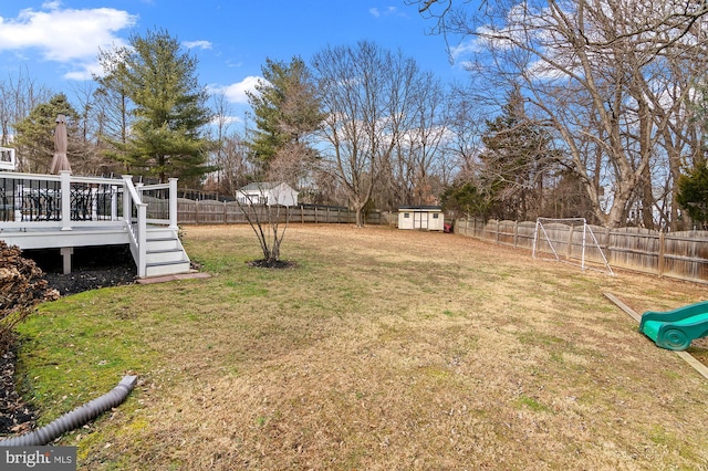 view of yard with a storage unit, a playground, and a deck