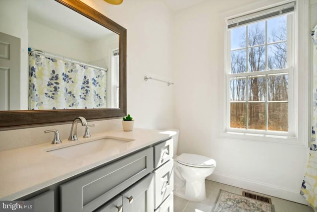 bathroom featuring vanity, tile patterned flooring, and toilet