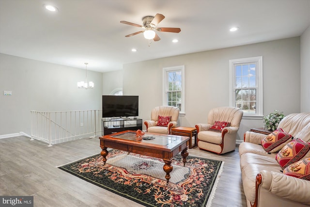 living room featuring hardwood / wood-style flooring and ceiling fan with notable chandelier