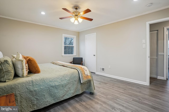 bedroom with crown molding, hardwood / wood-style floors, and ceiling fan