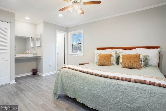 bedroom with ceiling fan, hardwood / wood-style floors, ensuite bathroom, built in desk, and ornamental molding