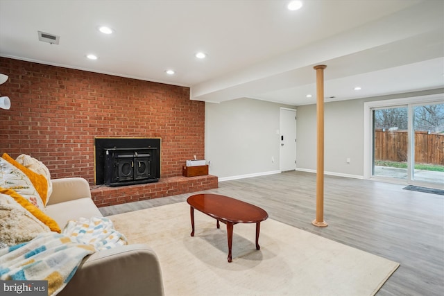 living room featuring brick wall and light wood-type flooring