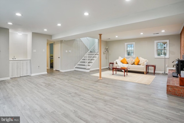 living room with a wood stove and light wood-type flooring