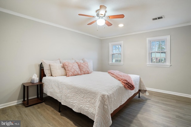 bedroom with crown molding, ceiling fan, and dark hardwood / wood-style floors