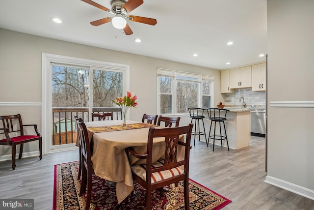 dining space featuring sink, ceiling fan, and light hardwood / wood-style flooring