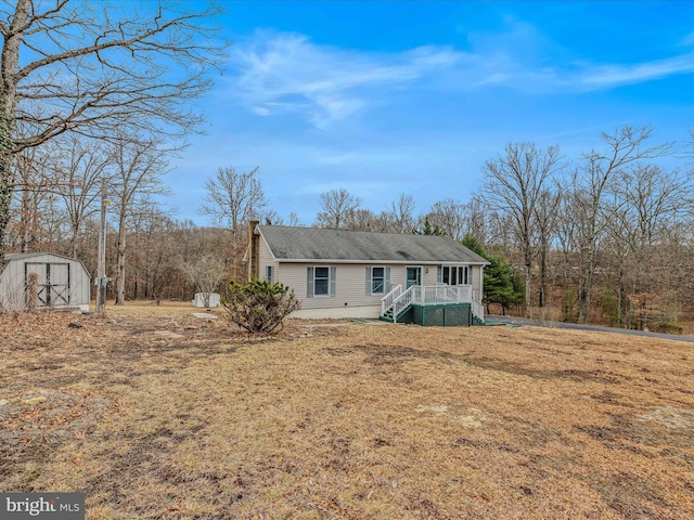 single story home featuring a front yard and a shed