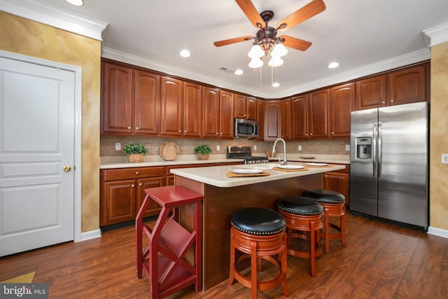 kitchen featuring stainless steel appliances, light countertops, dark wood finished floors, and tasteful backsplash