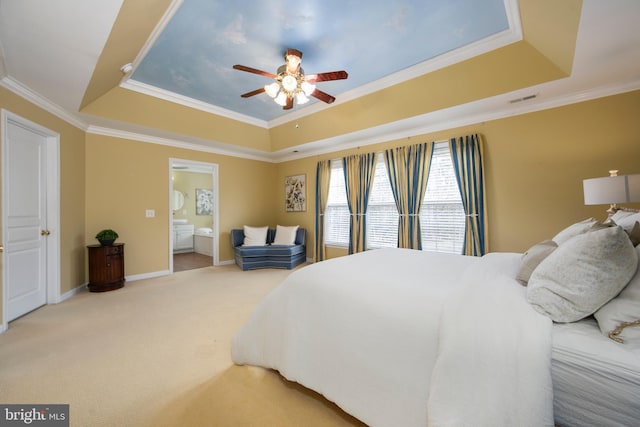 bedroom with a raised ceiling, ensuite bathroom, ornamental molding, carpet flooring, and baseboards