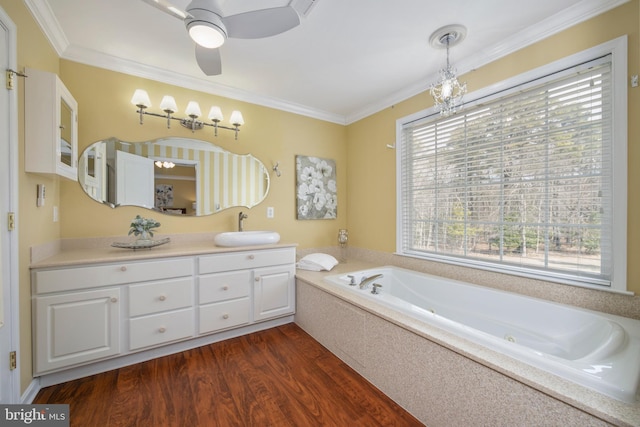 bathroom with a jetted tub, wood finished floors, vanity, and crown molding