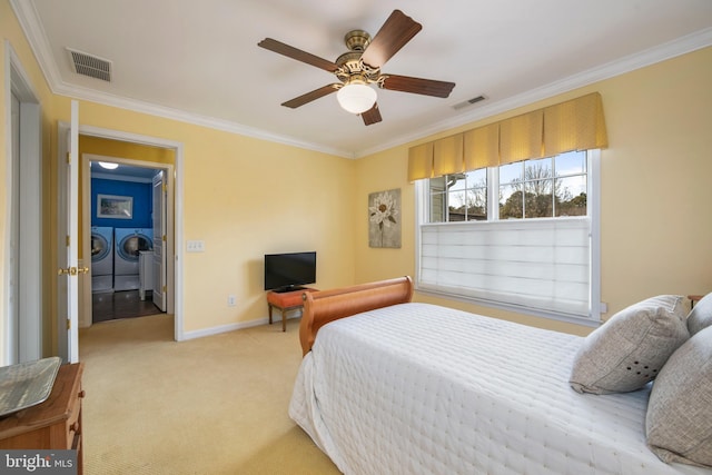 bedroom featuring ornamental molding, light colored carpet, visible vents, and independent washer and dryer