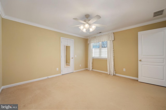 empty room featuring ornamental molding, visible vents, light carpet, and baseboards