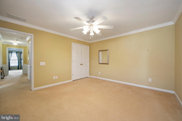 unfurnished bedroom featuring ornamental molding, a closet, light carpet, and baseboards