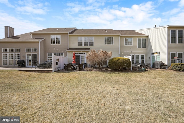 rear view of property with a lawn and a patio