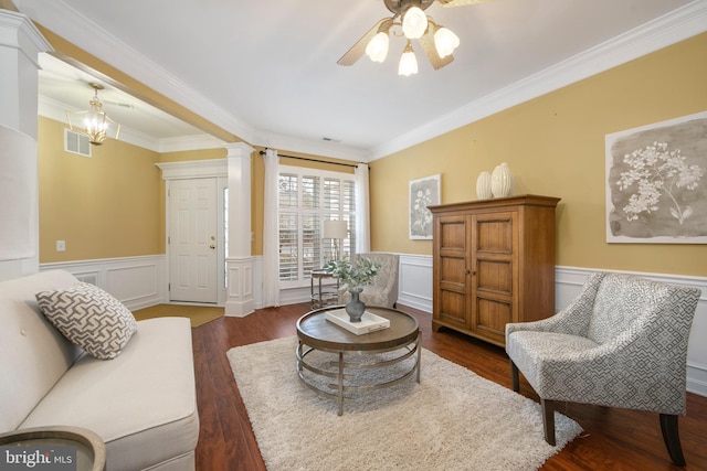 living area featuring dark wood-style floors, decorative columns, crown molding, visible vents, and wainscoting